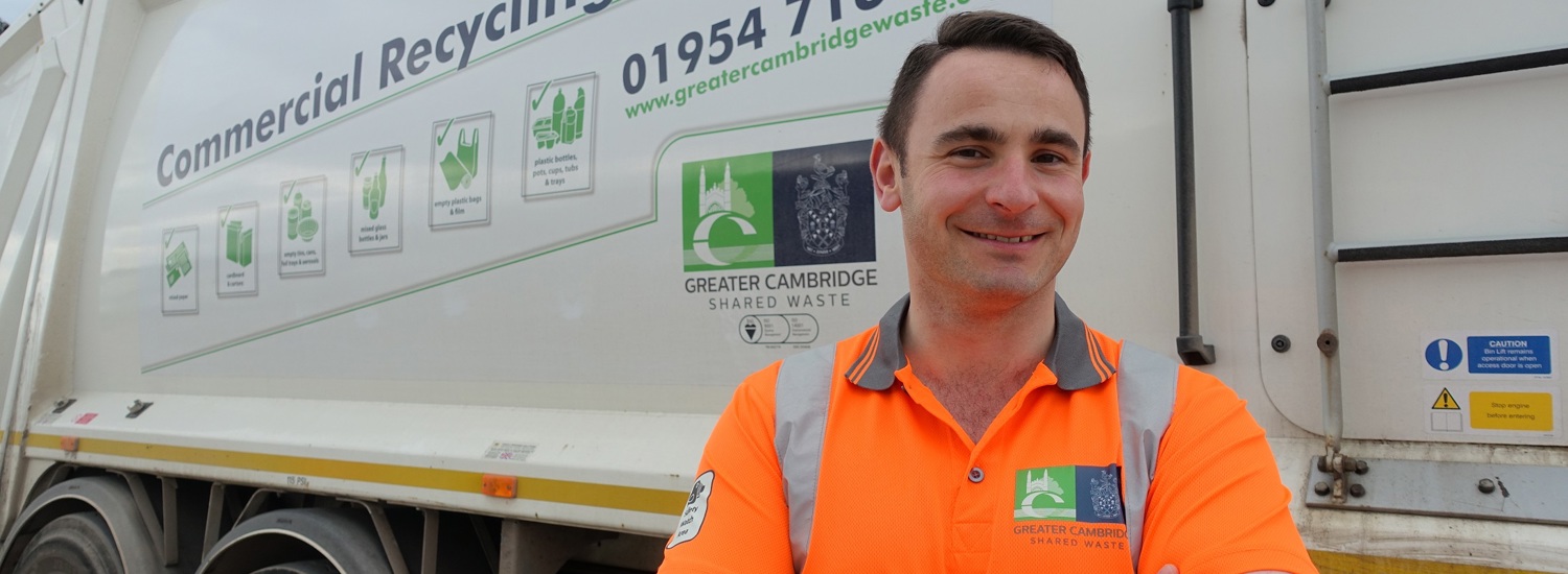 Worker stood in front of an electric bin lorry